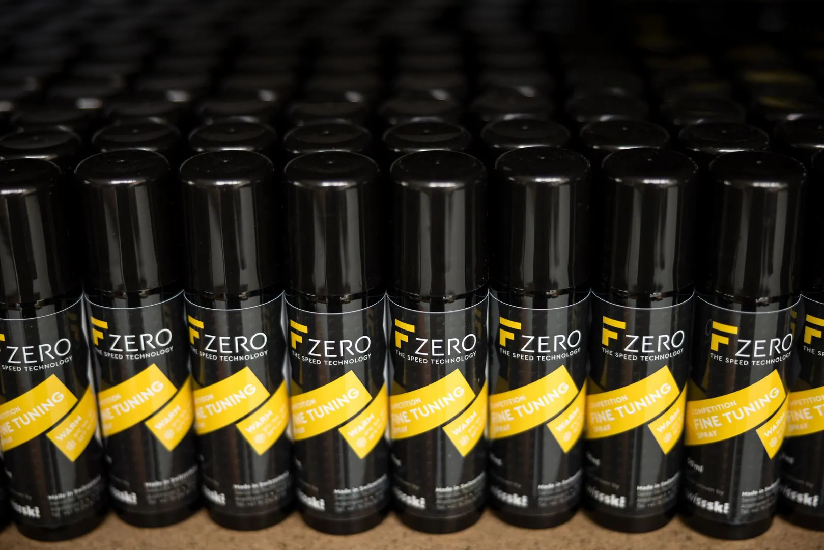 Viele schwarze FZero Spray Dosen stehen dicht an dicht in mehreren Reihen. Auf jeder Dose ist ein gelbes Etikett.
