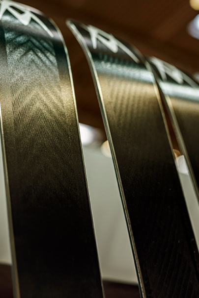 Schwarze Skier mit Muster Drei schwarze Skier, die nebeneinander stehen, mit silbernen Mustern auf der Oberseite und einer glatten, glänzenden Oberfläche.