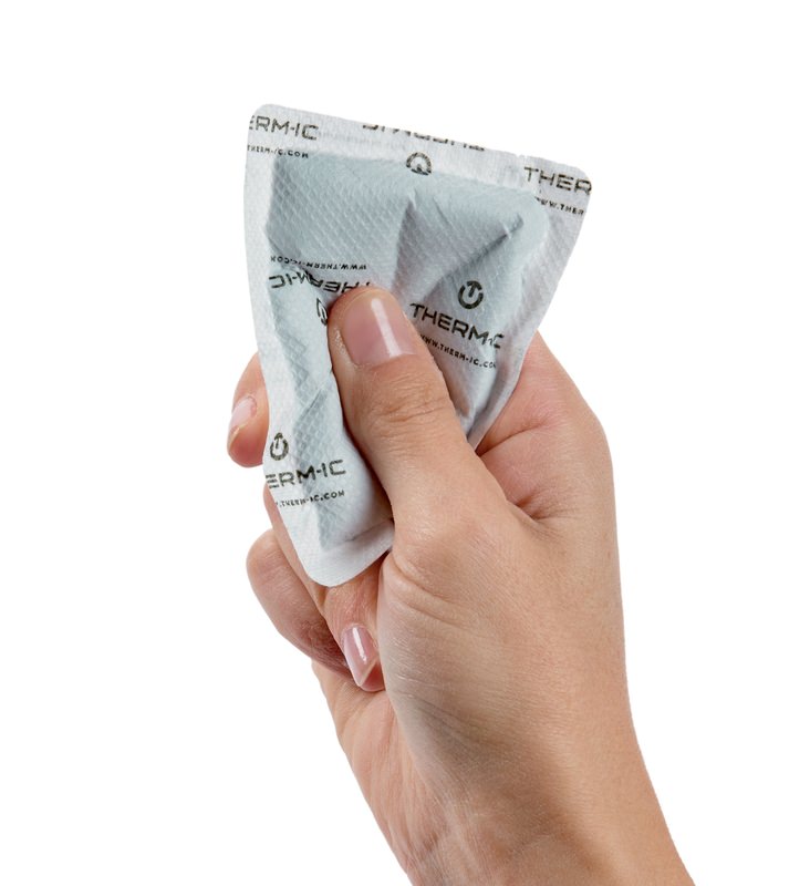 Eine Hand hält eine weiße, rechteckige Therm-ic Pocket Warmer Verpackung mit Logo.