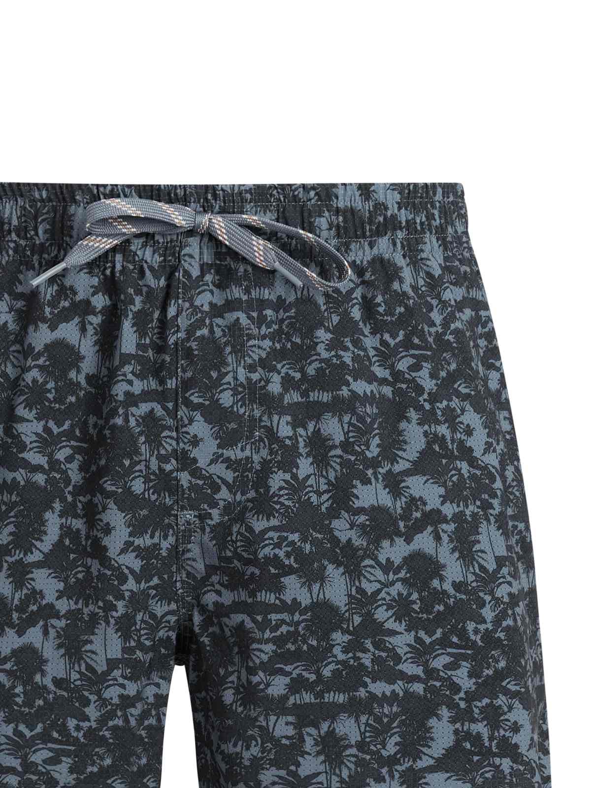 Nahaufnahme einer Shorts mit dunklem Palmenmuster und grau-brauner Kordel am elastischen Bund.