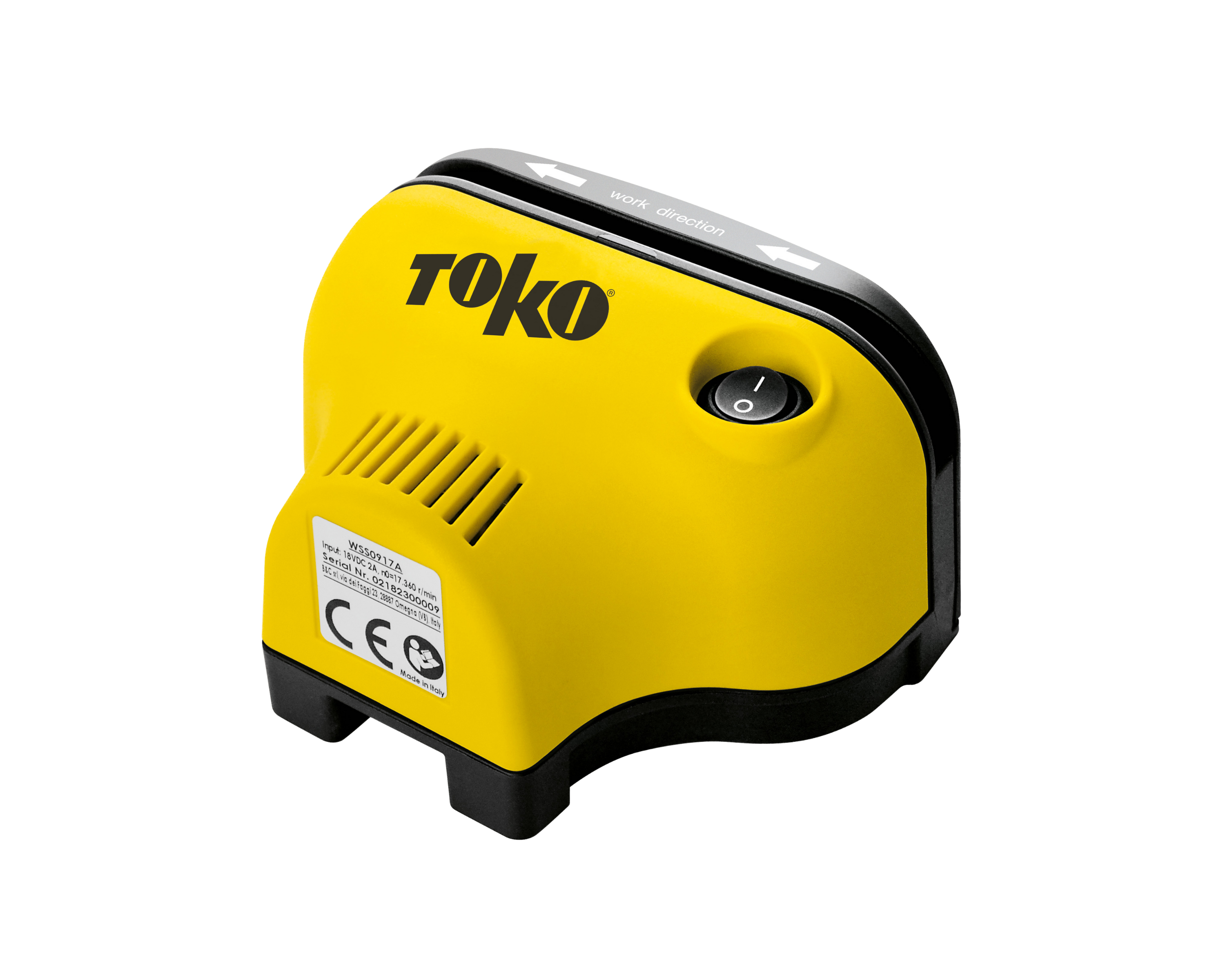 Gelbes Toko-Gerät mit schwarzem Rand und Beschriftungen. Pfeile zeigen die Arbeitsrichtung an. Ein runder Einschaltknopf ist sichtbar.