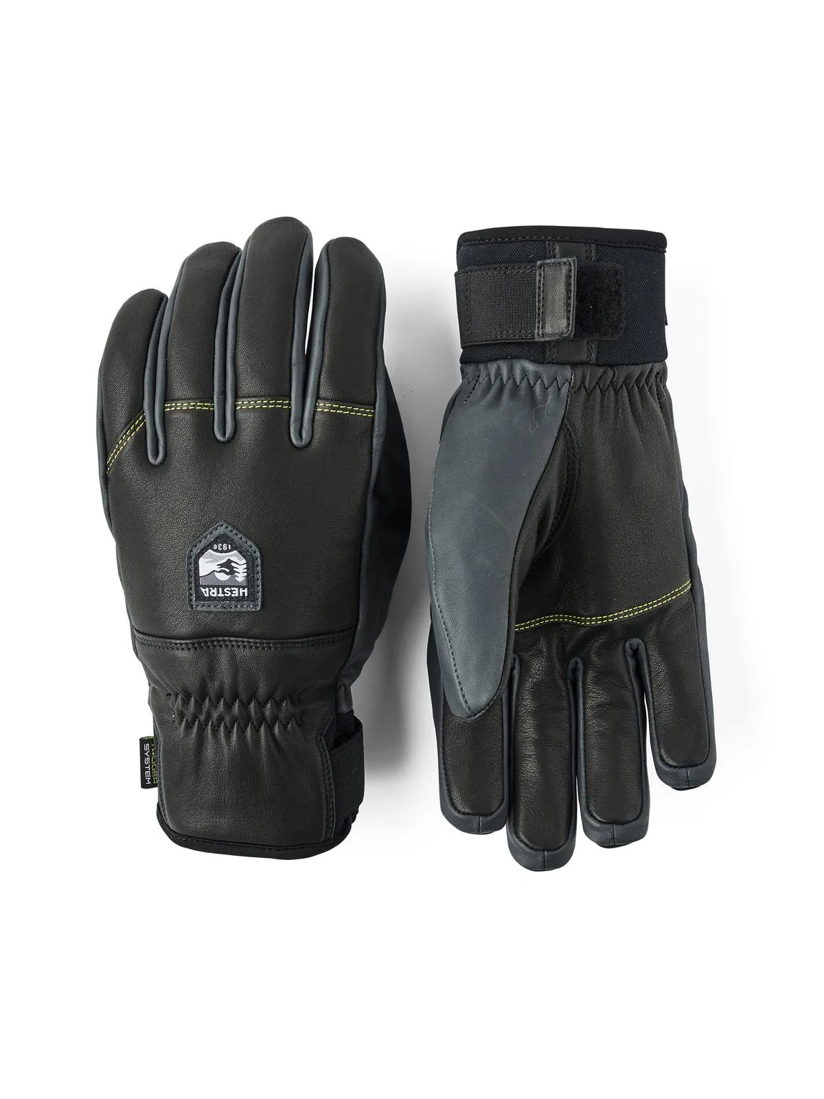 Zwei schwarze Hestra Omni Trigger Handschuhe, einer mit sichtbarem Handgelenkbund, auf weißem Grund.
