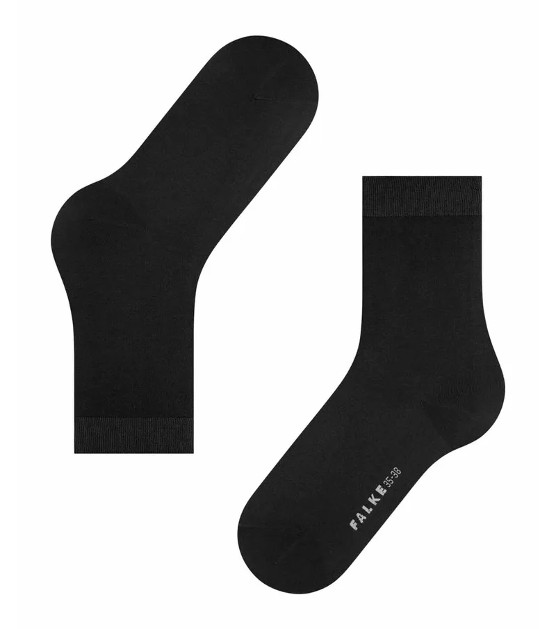 Two black women's socks, one lying down, the other upright with the lettering FALKE.