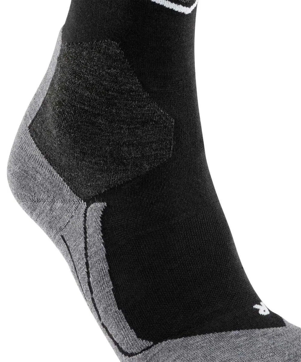 Zoom sur une chaussette noire montant à la cheville, du talon au milieu du pied. Zones tricotées grises au talon et à la voûte plantaire pour un bon maintien. Motifs visibles pour confort et respirabilité. Logo blanc au bord.