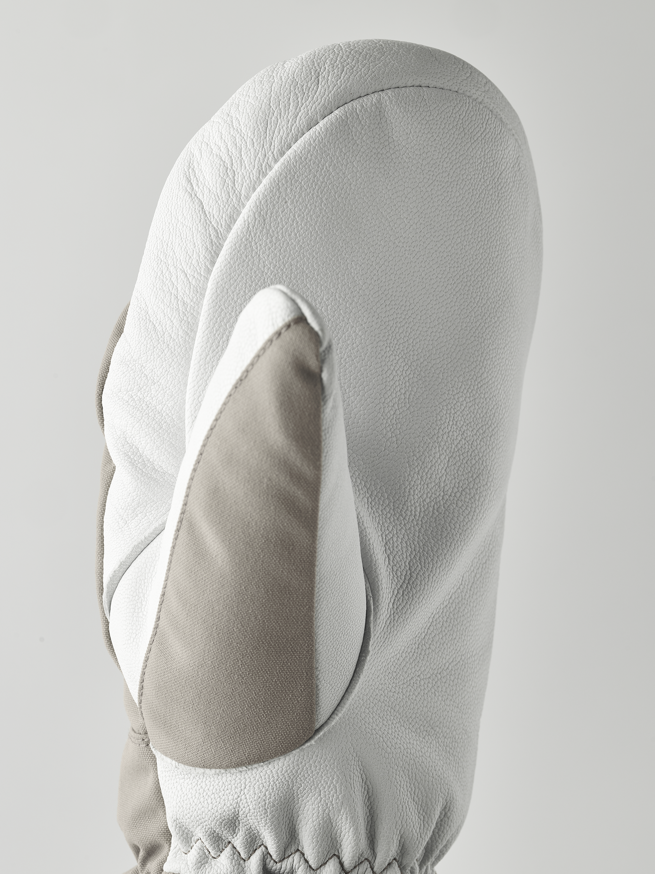 Hestra Army Leather Heli Gant de ski Vue détaillée de Hestra Army Leather Heli Ski Mitt en gris et blanc. La structure du cuir est reconnaissable.