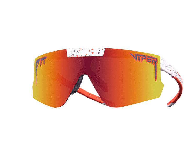 Lunettes de soleil avec verres orange, monture et branches mouchetées de blanc.