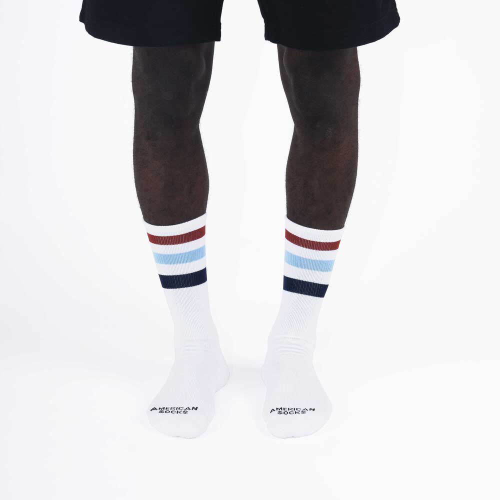 Gestreifte Mid High Socken Beine mit weißen Mid High Socken, farbige Streifen (braun, hellblau, blau) am oberen Sockenrand.