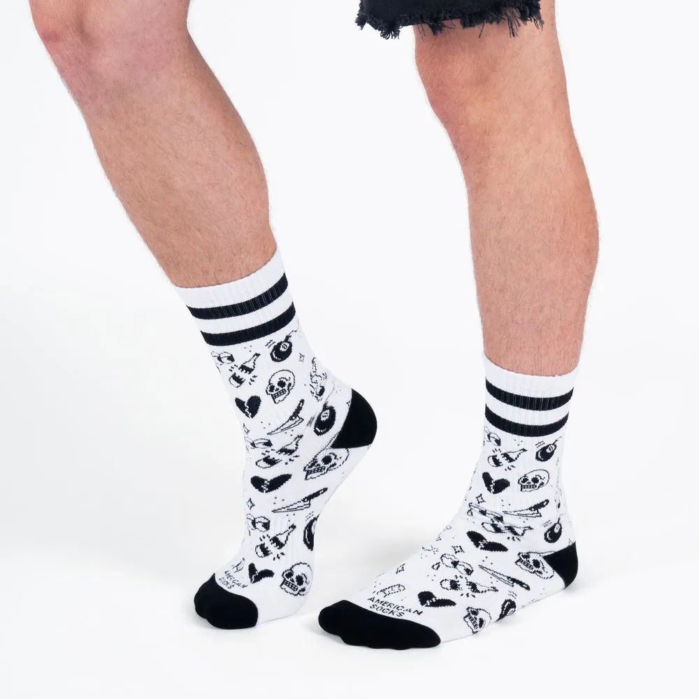 Legs with white, medium-high socks, black cuffs and stripes. Socks with flash tattoo motifs, such as skulls.
