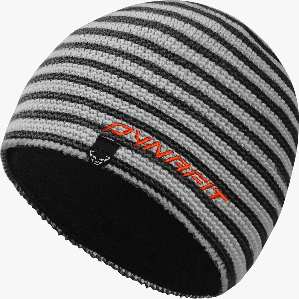 Handgestrickte Dynafit Mütze in grau-schwarz gestreift, mit orangenem Logo und schwarzem Fleece-Innenfutter.