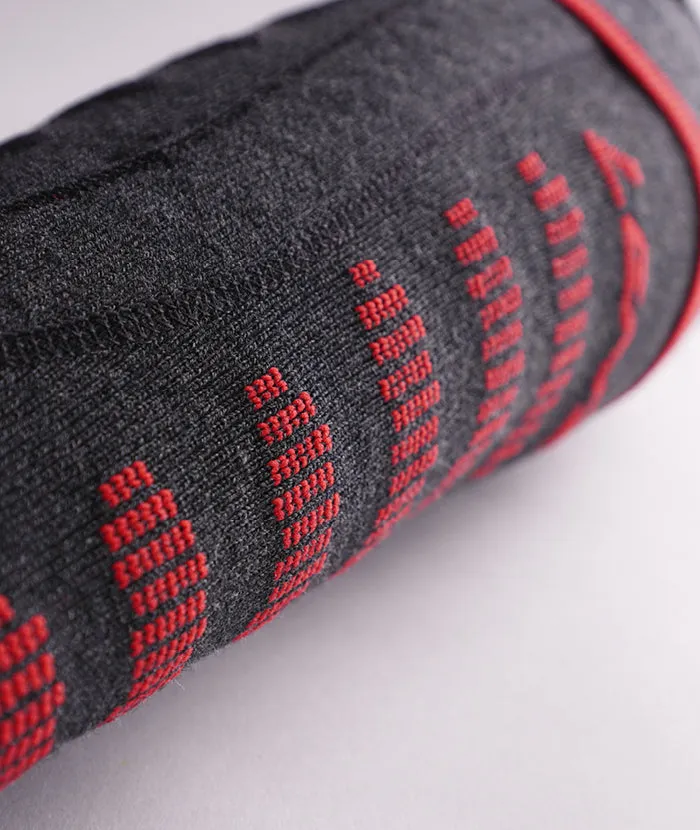 Pièce de tissu grise, roulée, avec des lignes de points verticales rouges sur un fond clair.
