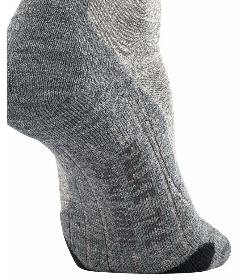 Close-up of a gray TK2 Wool men's trekking sock on the foot, with ribbed structure and lettering.