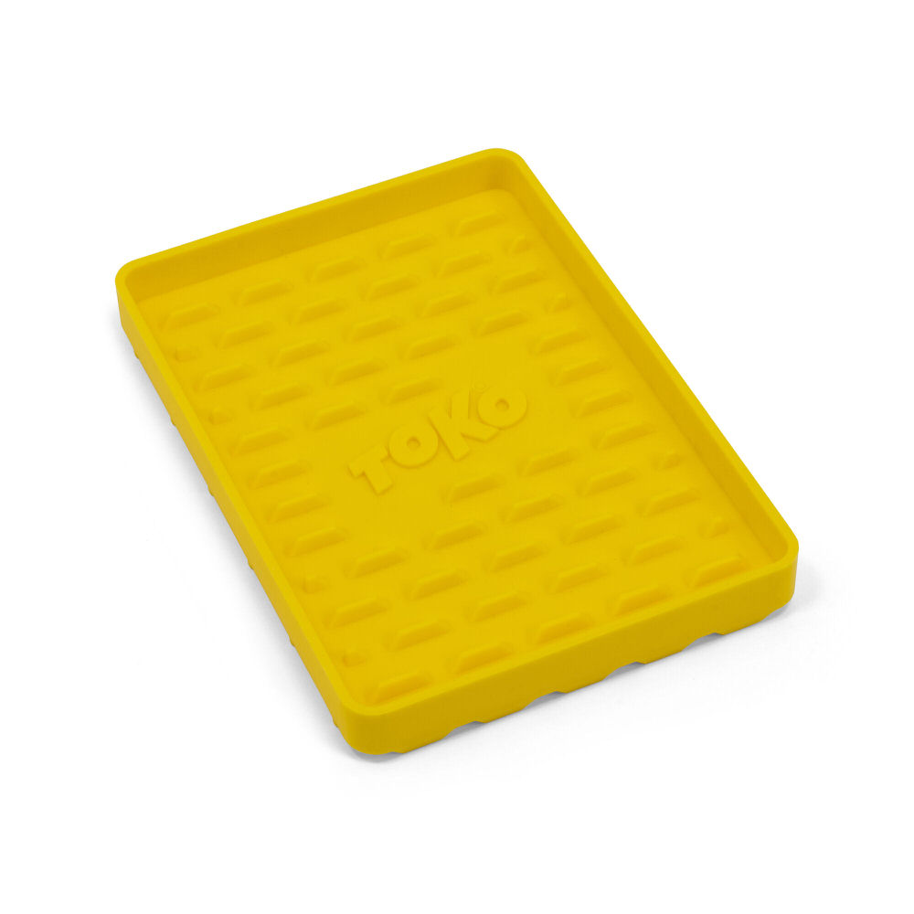 Gelbe, rechteckige Silikonmatte für Bügeleisen mit "Toko" Schriftzug und Rillenmuster.