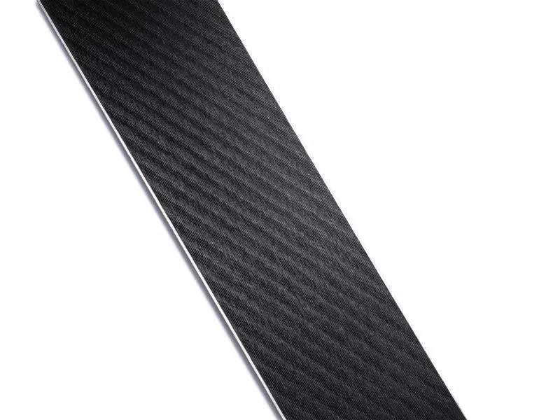 Oggetto nero di forma allungata con una trama fine e orizzontale si trova in diagonale su uno sfondo bianco.