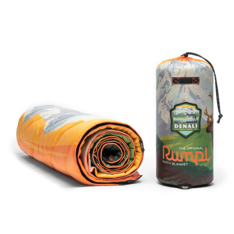 Gerollte Denali National Park Rumpl Puffy Decke, daneben eine passende Tragetasche mit Kordelzug.