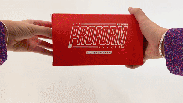 "Boîte à lunettes Proform rouge" Ouverture par les mains de la Proform Goggle Box rouge avec l'inscription "Go Biggerer" sur fond blanc.