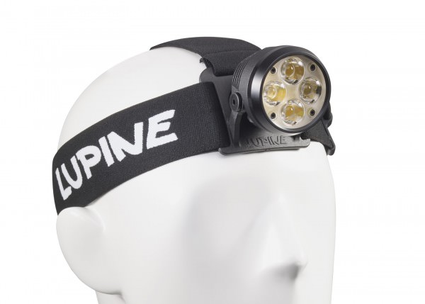 Schwarze Wilma RX 7 Stirnlampe mit vier LEDs an weißem, formlosen Kopf befestigt. Das Stirnband trägt den Schriftzug "Lupine".