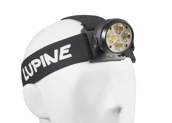 Lampe frontale Wilma RX 7 noire avec quatre LED fixées sur une tête blanche sans forme. Le bandeau porte l'inscription "Lupine".