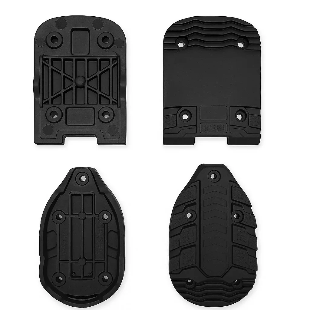 Four black ski binding plates in different shapes and textures on a white background.