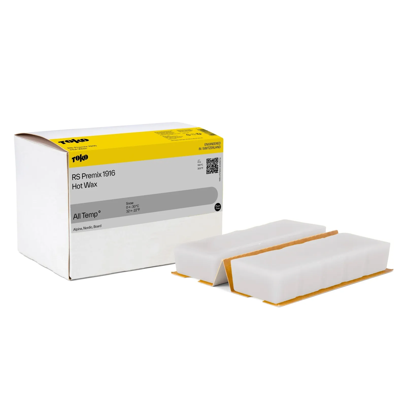 White cardboard packaging with yellow print next to two white wax blocks with a brown base.