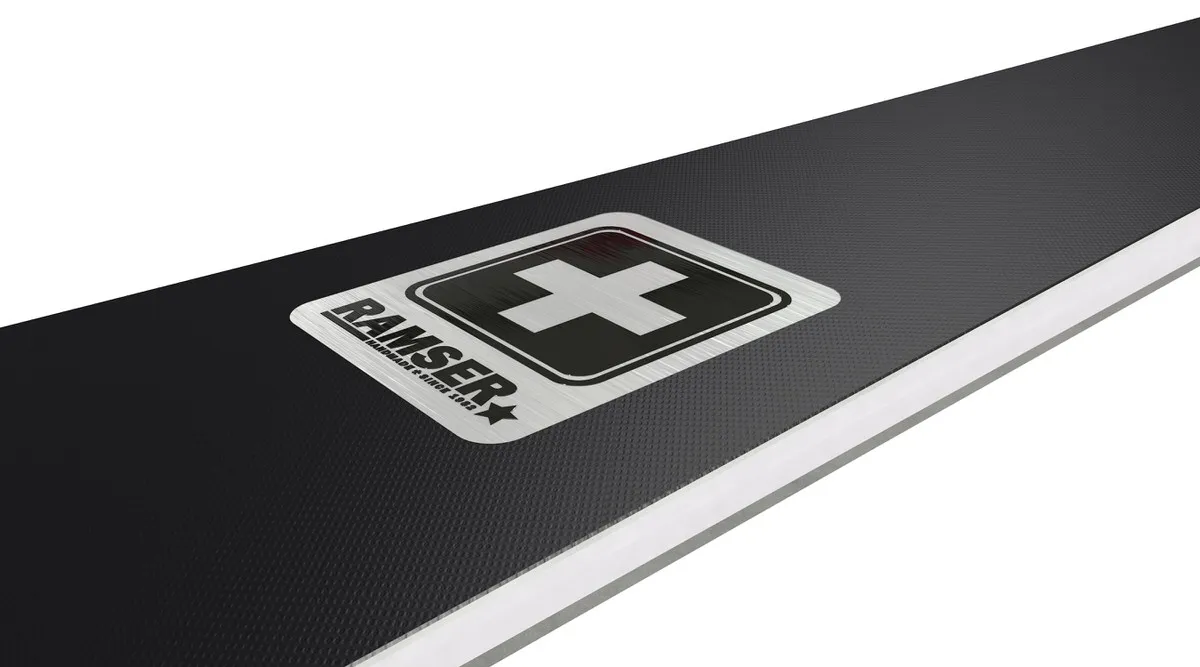 Detailed view: Ramser White product with logo and Swiss cross on a black, textured background.