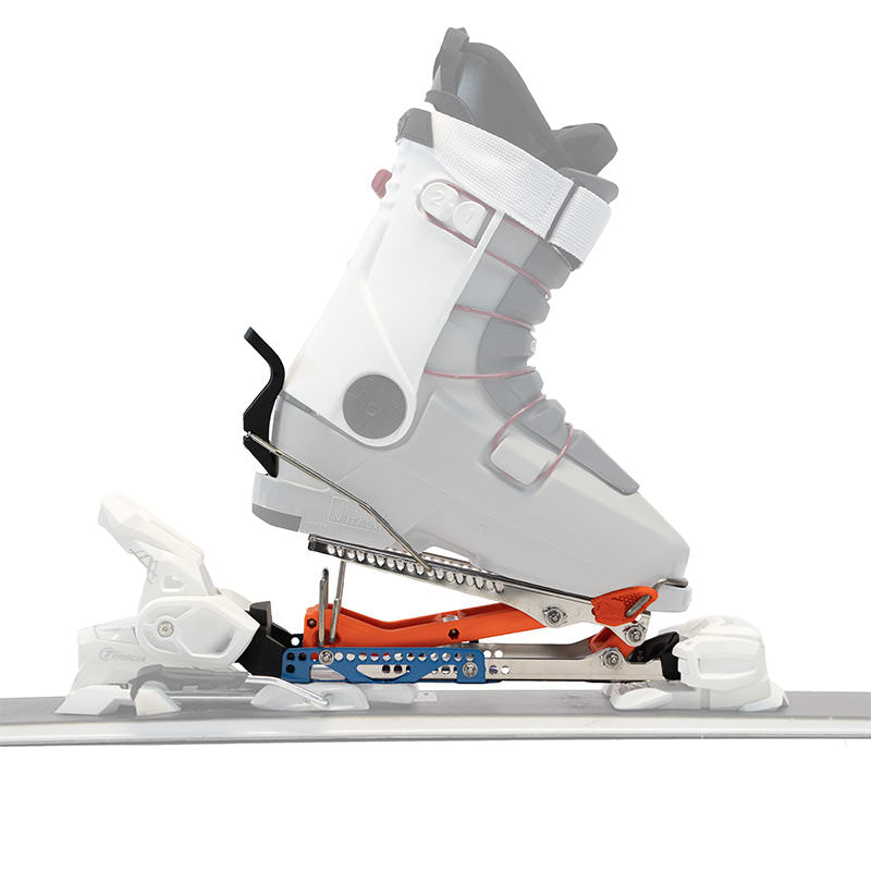 Nahaufnahme: Ski-Tourenadapter mit Skischuh montiert. Metall, orange und blaue Akzente. Ski ist sichtbar.