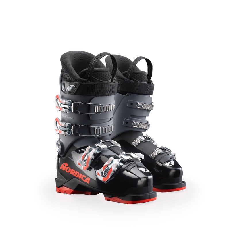 Zwei Nordica Speedmachine J 4 Skischuhe, seitlich, mit Schnallen und roter Akzentfarbe, vor weißem Hintergrund.
