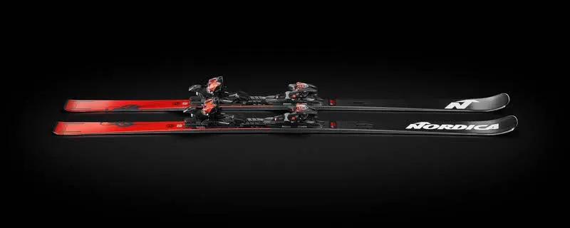 Les skis Nordica Dobermann GSR RB FDT avec fixation montée sont parallèles sur un fond noir. Design rouge et noir.