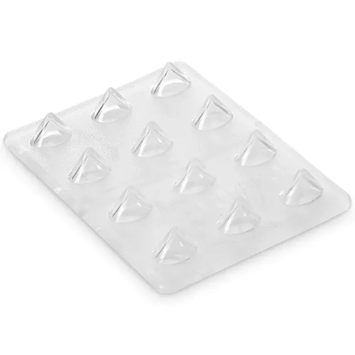 Clear, rectangular pad with 12 transparent, pyramid-shaped spikes arranged in four rows. The slightly textured surface of the Crab Grab Mini Shark Teeth Stomp Pad provides extra grip and is made of flexible rubber.