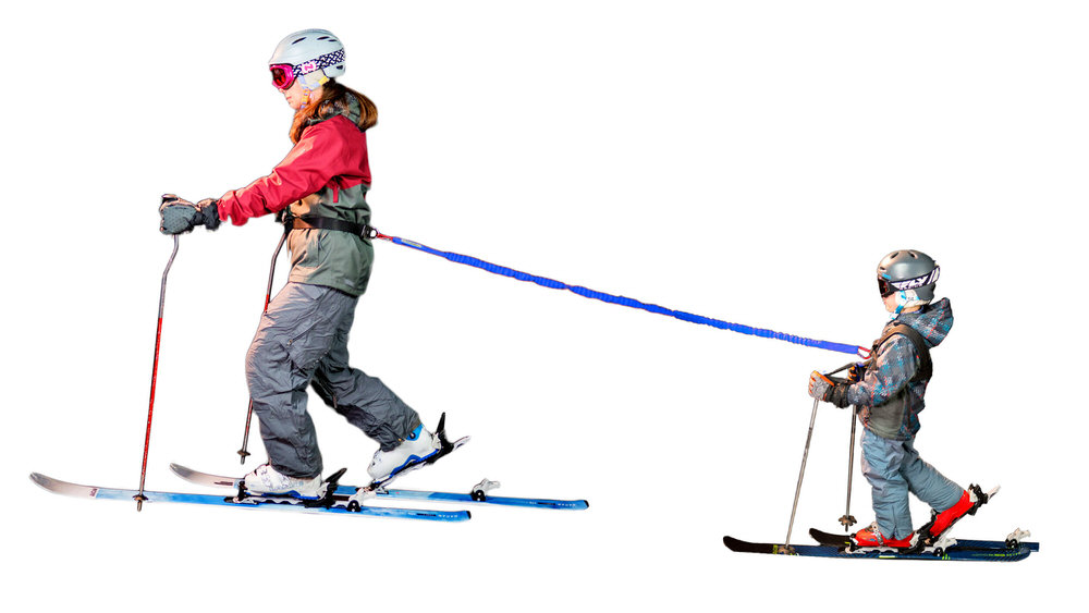 Zwei Skifahrer verbunden durch einen Tow-Whee Hüftgurt: Erwachsener zieht Kind auf Skiern. Blaue Zugschnur verbindet die beiden.