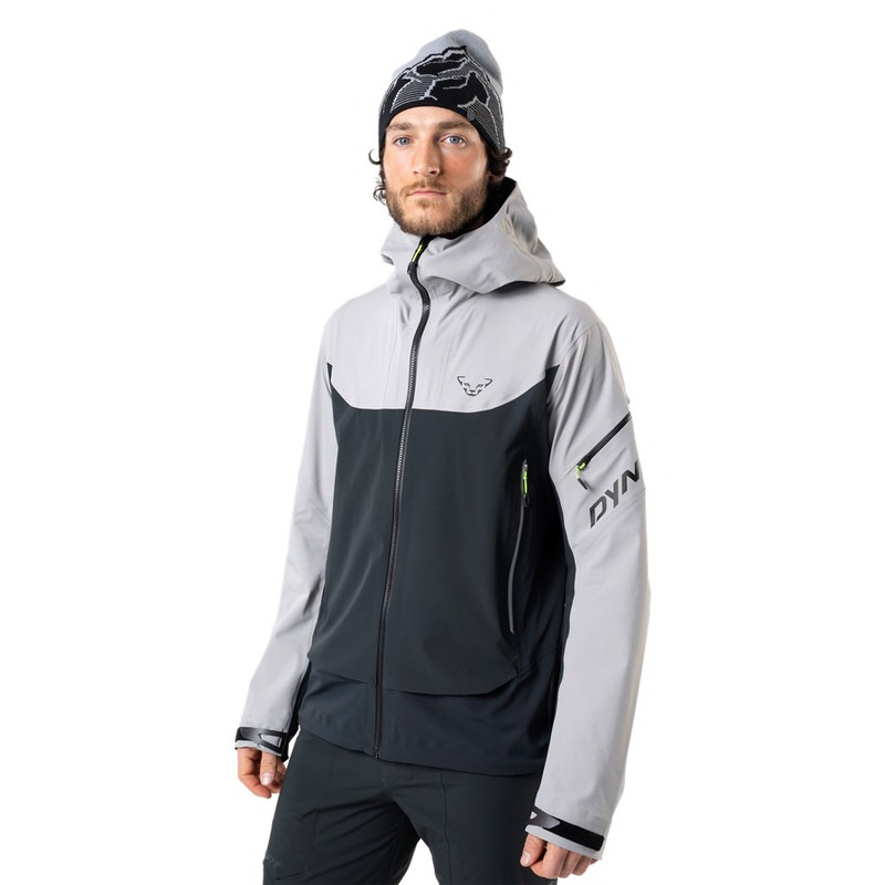 Ein Mann mit Mütze trägt eine graue Dynafit Beast Hybrid Jacke mit Kapuze.