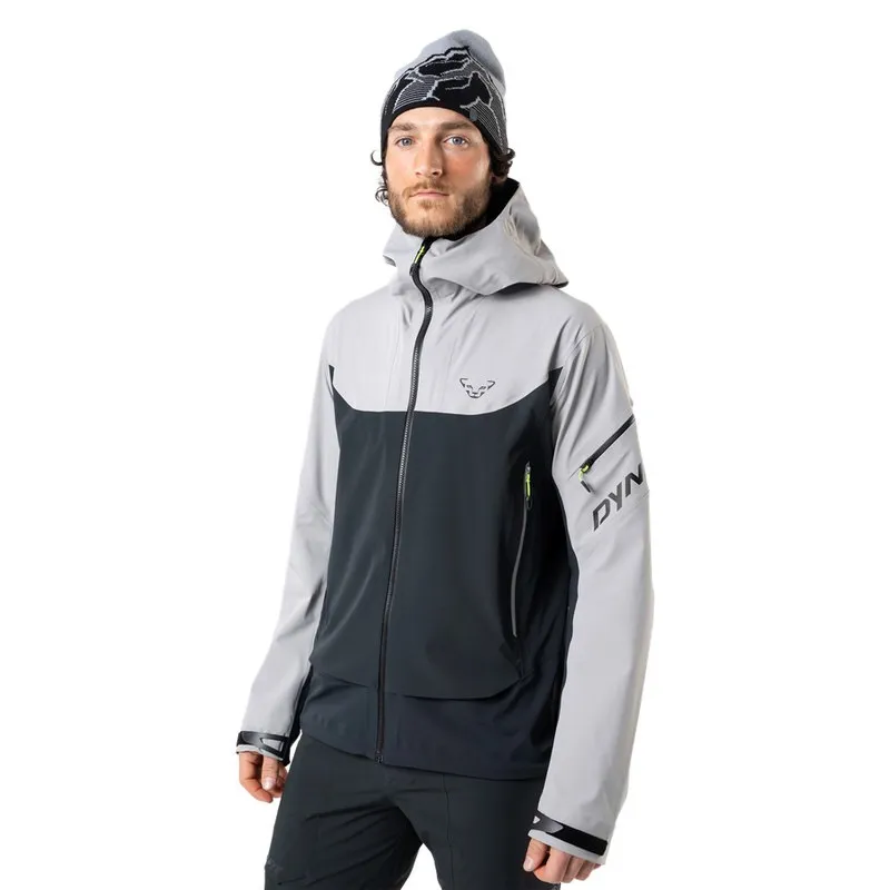 Un uomo con un berretto indossa una giacca Dynafit Beast Hybrid grigia con cappuccio.