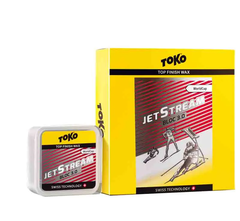 Confezione gialla della sciolina Toko JetStream Bloc 3.0, con illustrazione dello sciatore. Piccolo blocco di sciolina a sinistra.