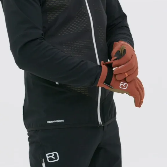 Person puts on Rock'n'Wool Glove Liner in red-brown, wears black sportswear.