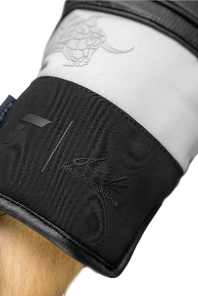 Nahaufnahme eines weißen Handschuhs mit schwarzem Bund, der den Namen "Henrik Kristoffersen" trägt.