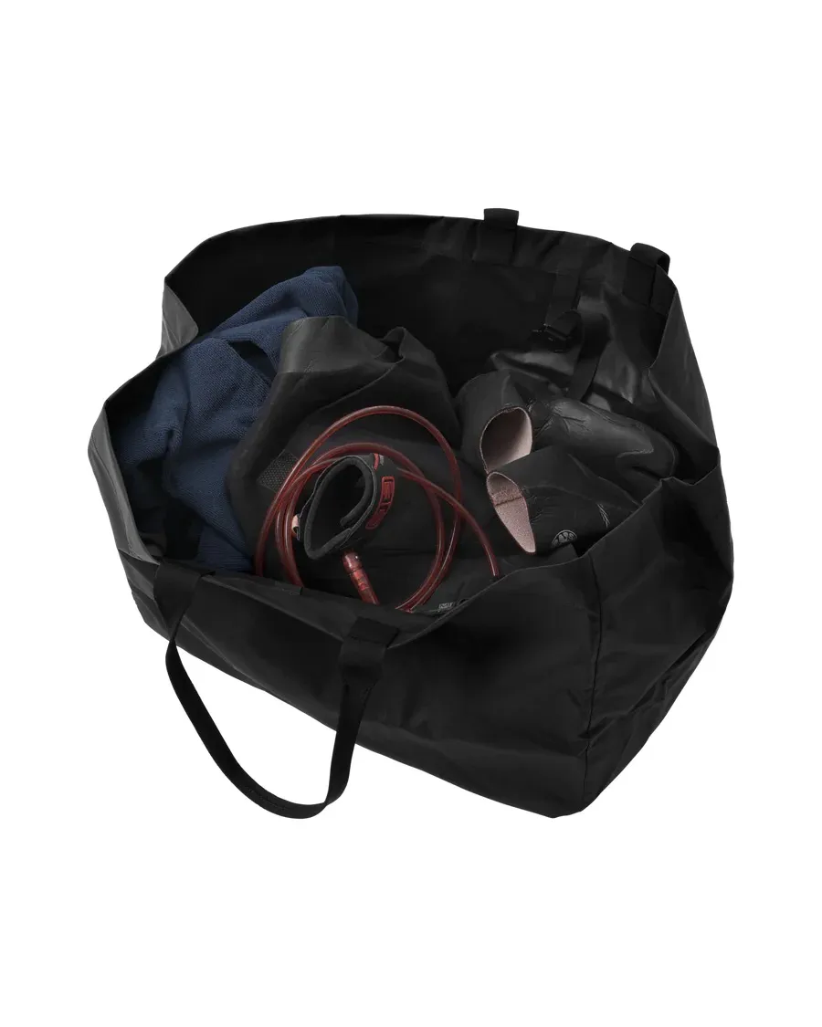 Totem Surf Essential noir ouvert 80L rempli de vêtements, de chaussures et d'une poche à eau.