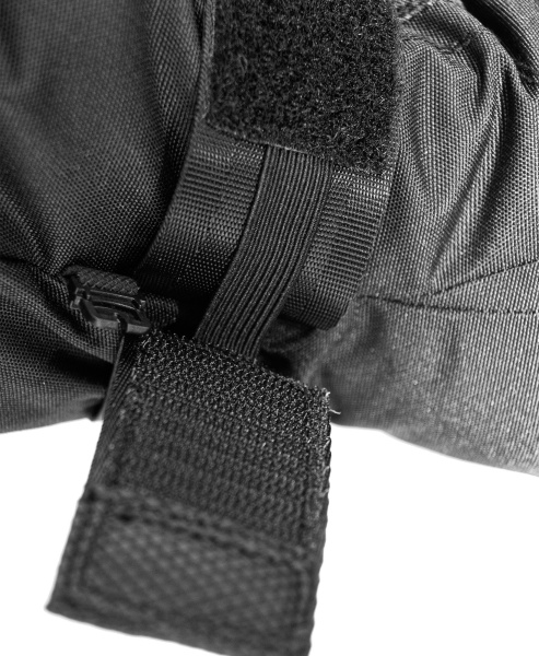 Schwarzes, strukturiertes Textil mit Klettverschluss und Riemen, Nahaufnahme.