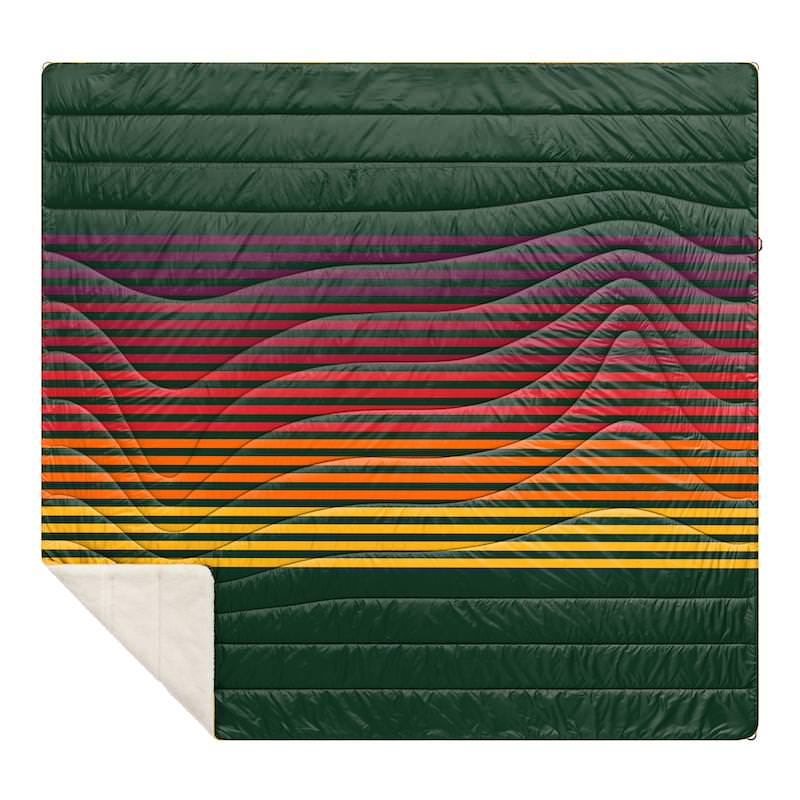Grüne Sherpa Puffy Blanket mit farbigen horizontalen Streifen von Lila über Rot nach Gelb, Fleece unten links sichtbar.