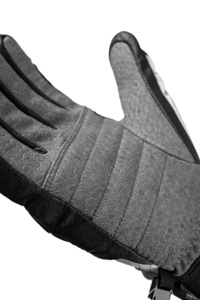 Nahaufnahme eines grauen Handschuhs mit Textur und schwarzen Details. Die Handfläche ist sichtbar und zeigt ein Muster.