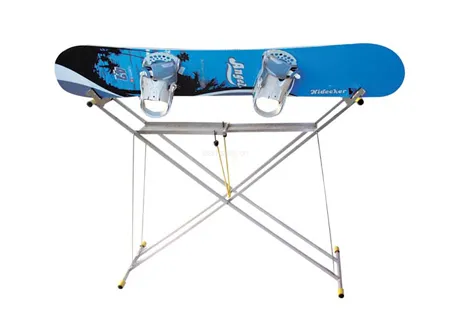 Snowboard blu su un tavolo di servizio pieghevole argentato con accenti gialli su sfondo bianco.
