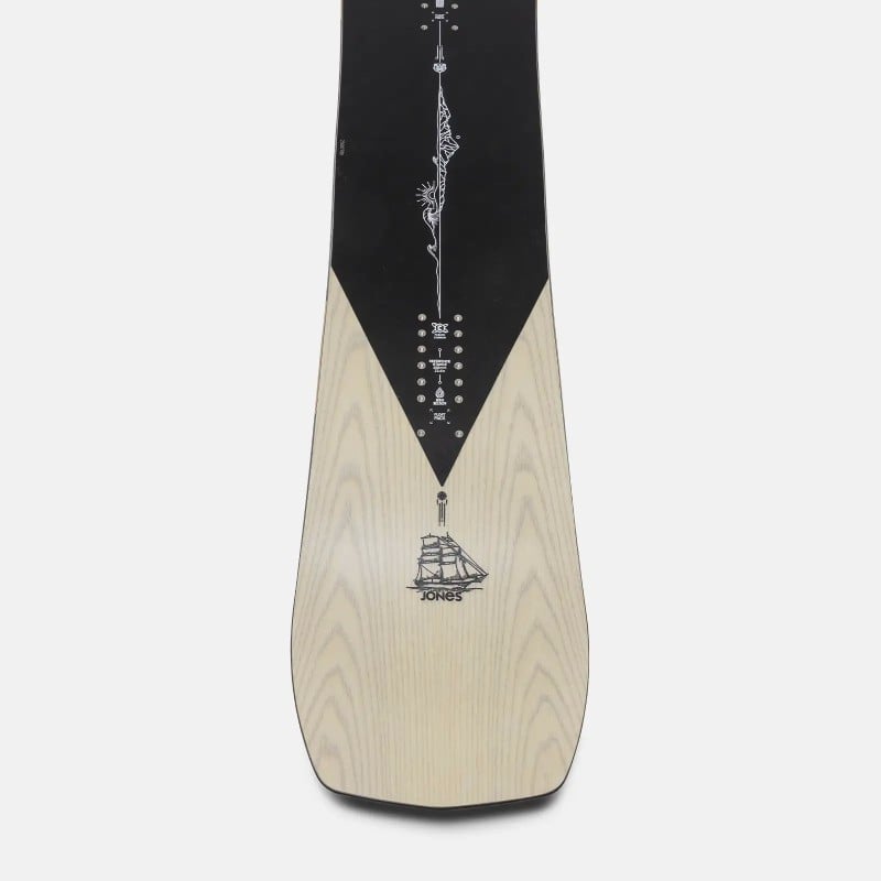 Snowboard Jones Flagship Pro Snowboard Jones Flagship Pro 25: Unterseite mit Holzoptik, Segelschiff-Grafik, schwarz-weisser Grafik am oberen Ende.