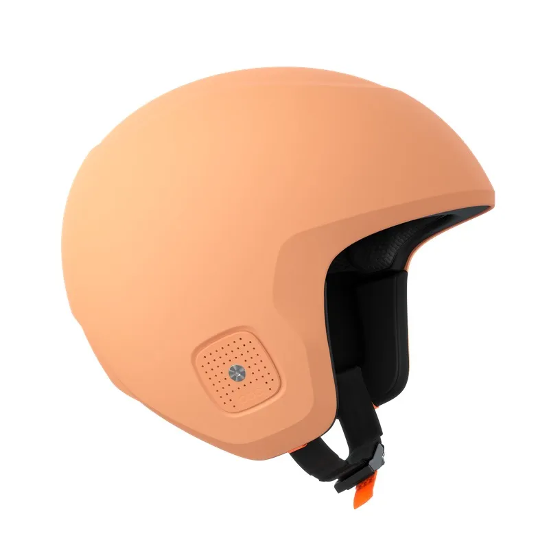 Peach-colored ski helmet with ventilation holes and black chin strap, slightly offset at the sides.