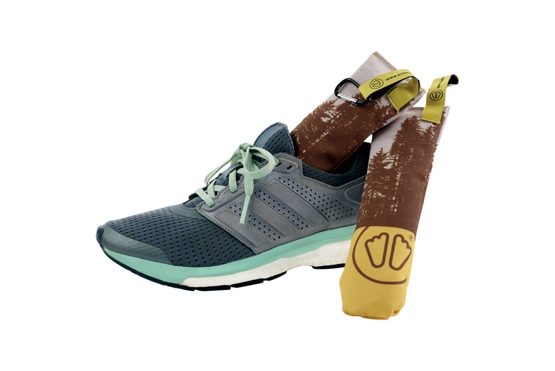 Chaussure de course grise avec sac Chaussure de course grise avec Sidas Cedar Wood Dryer Bag, avec motif d'arbre, dans la chaussure.