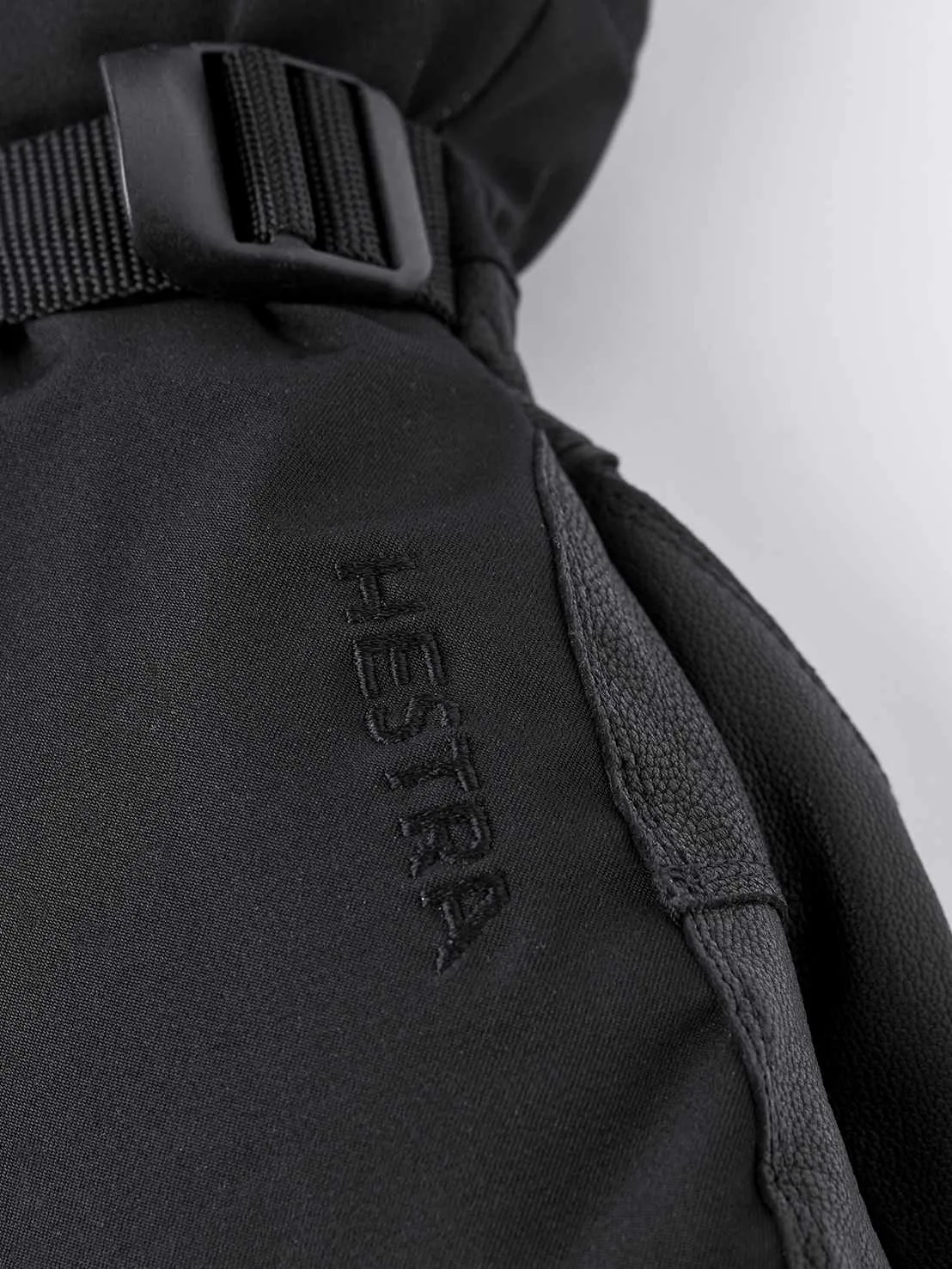Vista dettagliata del guanto Hestra Army Leather Extreme nero con logo e cinturino.