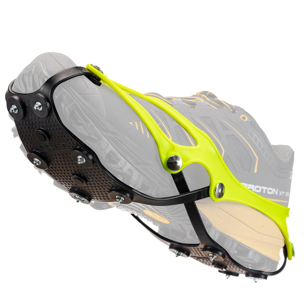 Nahaufnahme einer Corsa Schuhkralle mit Stahlspitzen, befestigt an einem Laufschuh. Das Hightech-Elastomer ist gelb und schwarz.