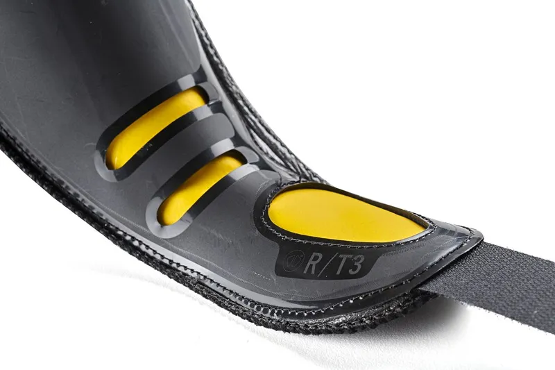 Detailed view of a black shoe with yellow accents and a strap.