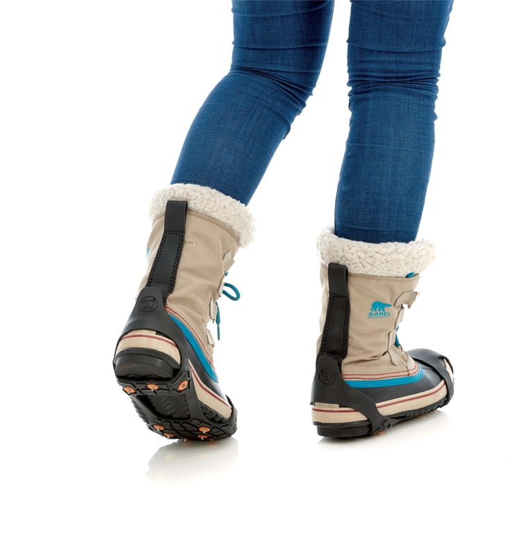 Person mit Schuhkrallen an Winterstiefeln. Nahaufnahme der Sidas Walk Traction für sicheren Halt auf Eis und Schnee.