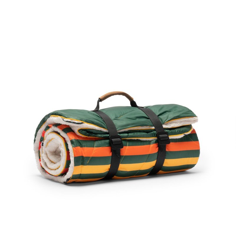 Gerollte, grüne Rumpl Sherpa Puffy Blanket mit farbigen Streifen und schwarzen Tragegurten.