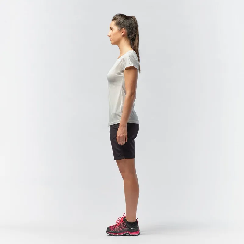 Frau von der Seite, trägt weißes Salewa Puez Melange Dry'Ton T-Shirt, Shorts und Bergschuhe.