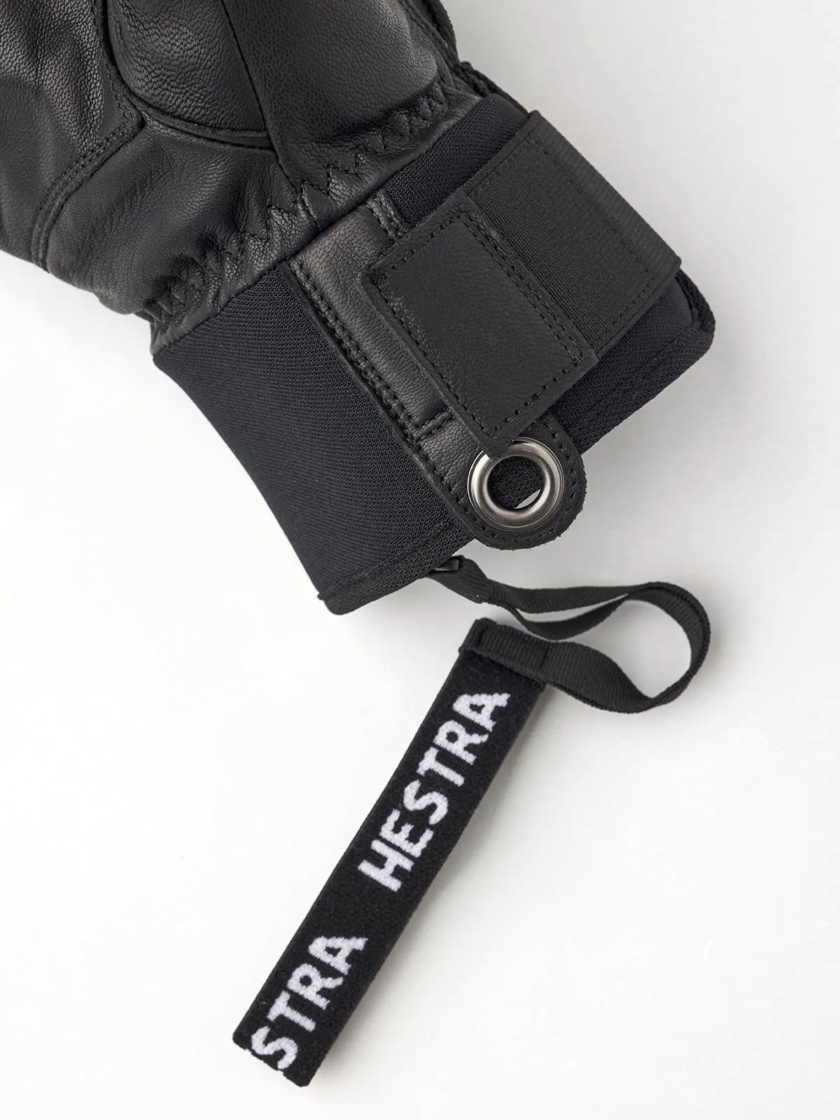 Detailaufnahme eines schwarzen Hestra Fall Line Skihandschuhs mit Markenanhänger.