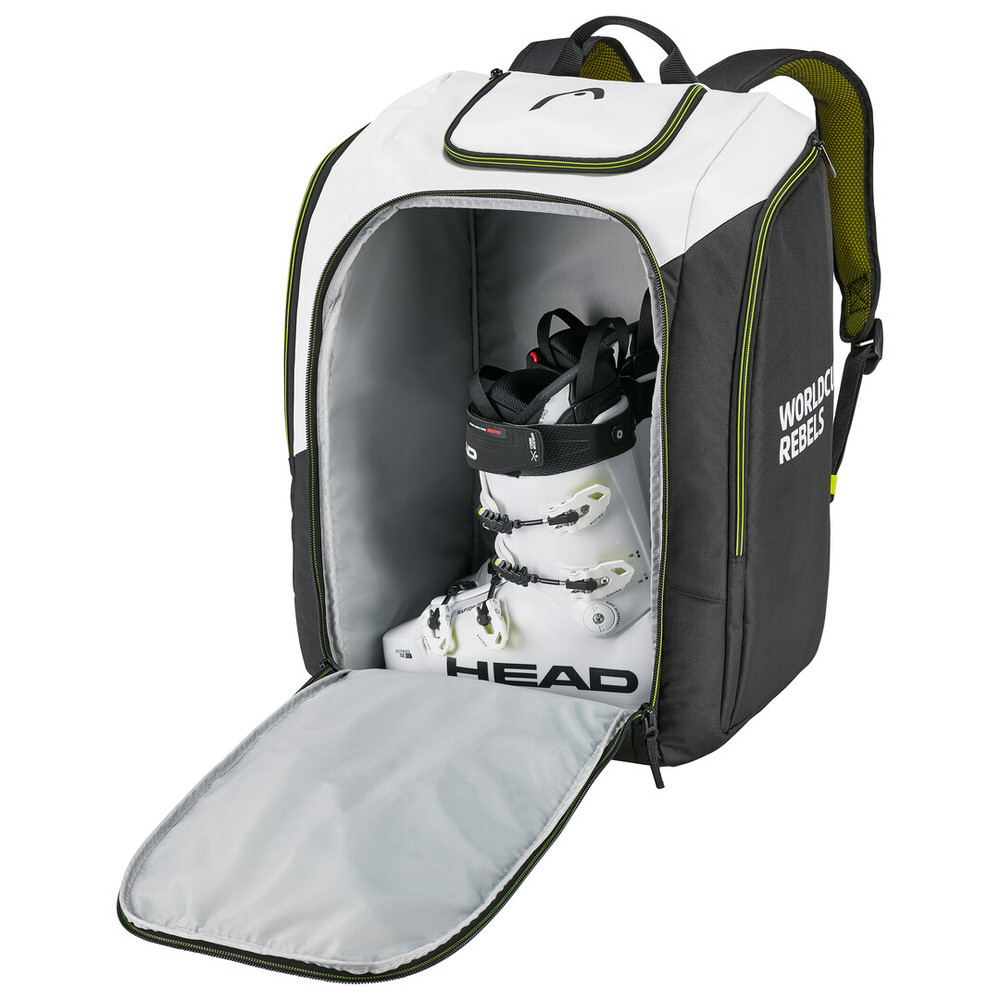 Opened Head Rebels Racing Backpack S, showing ski boot in main compartment. White, black, with carrying straps.